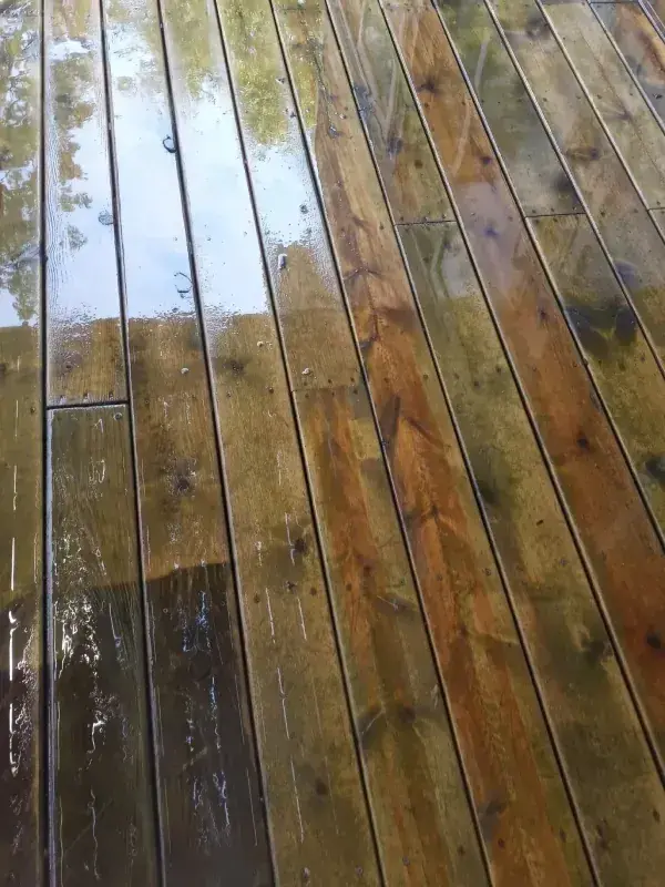 A wooden deck half cleaned and half still dirty