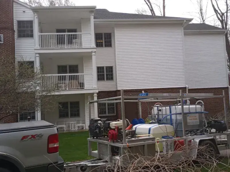 A commercial condominium building with the equipment trailer and truck parked in front